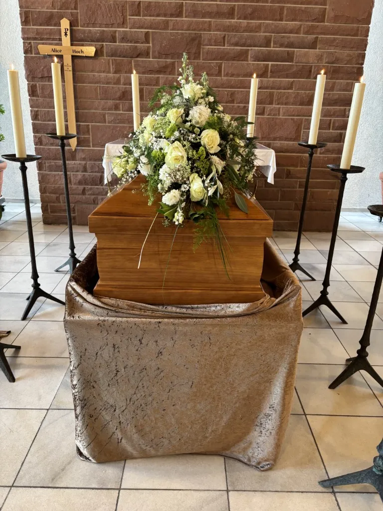 Sarg geschmückt mit weißen Rosen