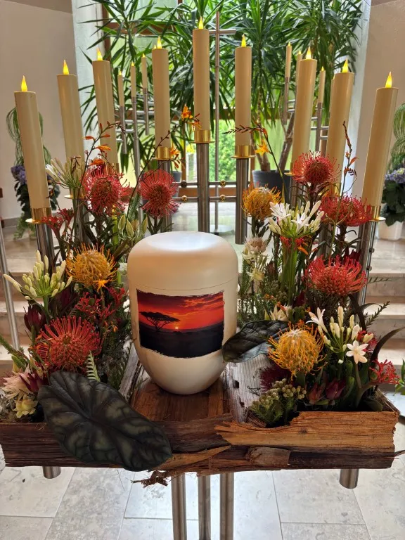 Urne umgeben von farbigen Blumen